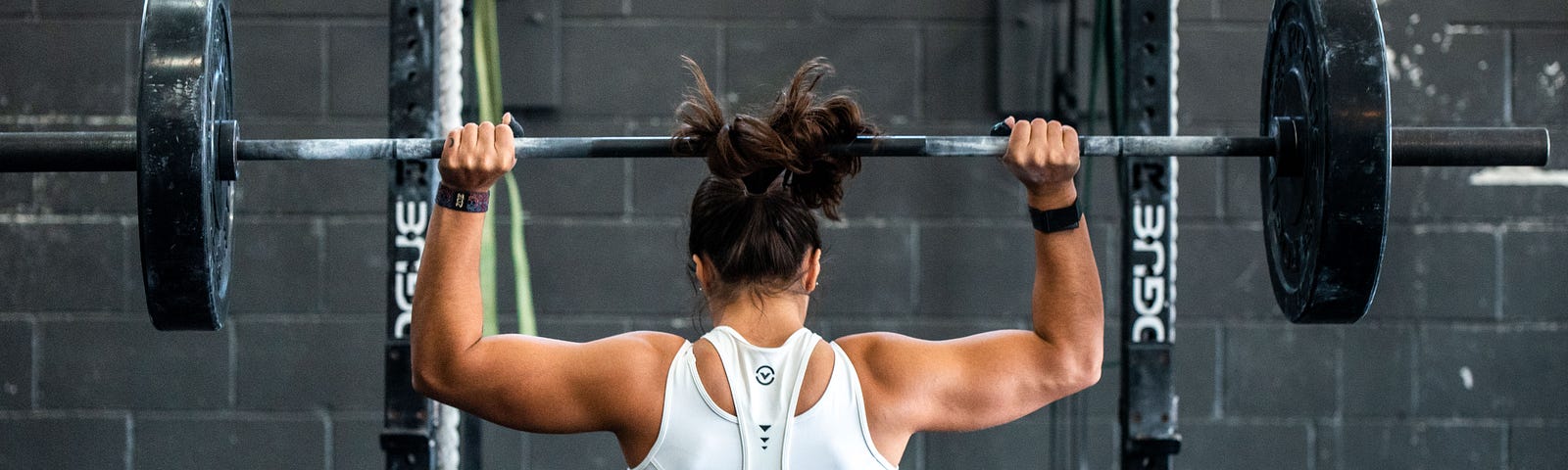 woman lifting a barbell, photo showing her backside