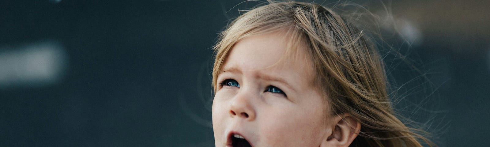 A little girl child looking to the sky with squinted eyes as though she just travel back in time.