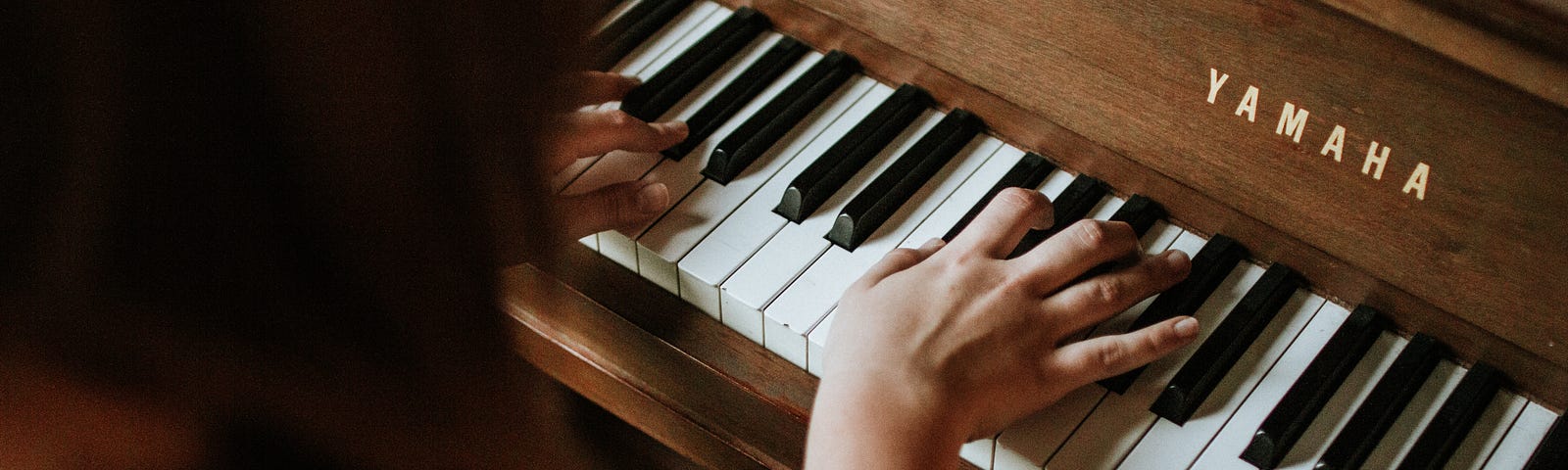 Woman’s hands playing a Yamaha piano