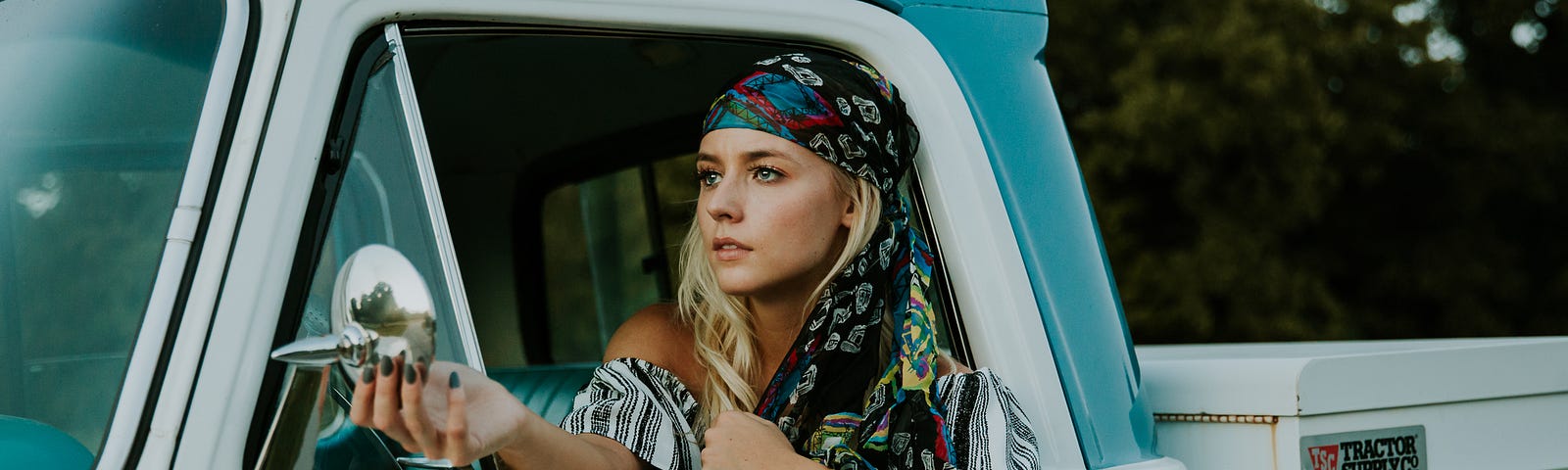 Woman in a headscarf driving a truck.