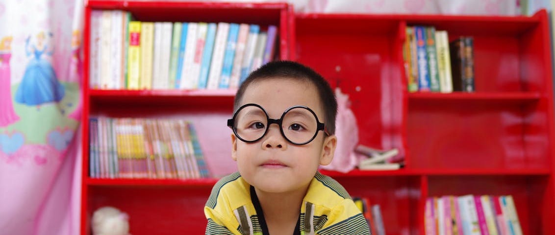 Boy standing near a bookshelf