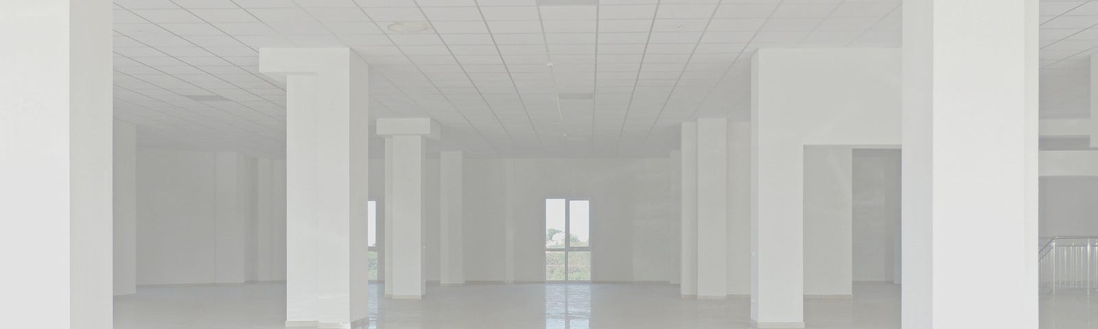 A large empty room, white columns flanking each side of center perspective.