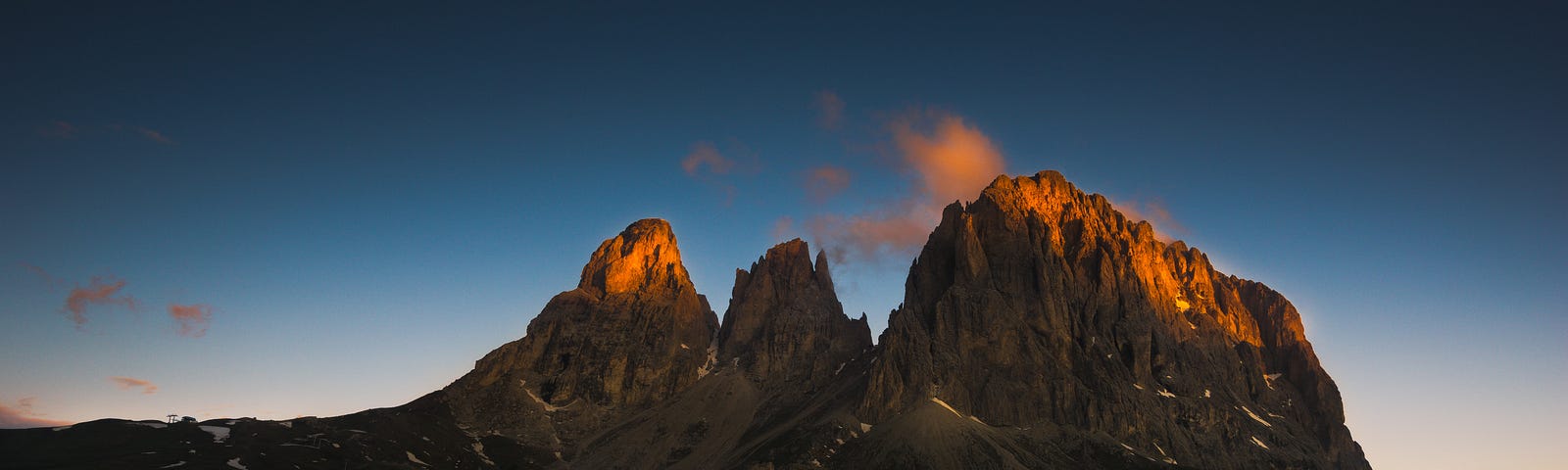 The first rays of sun illuminate the tips of majestic mountain peaks