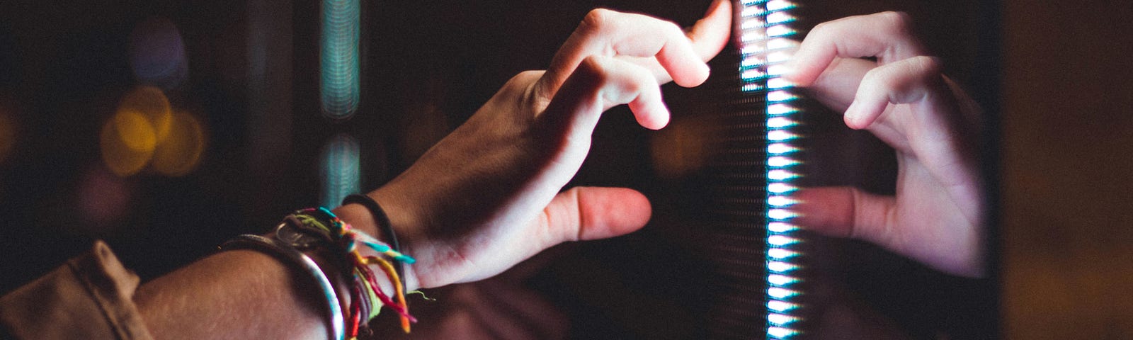 A hand touching glass and reflected back at itself