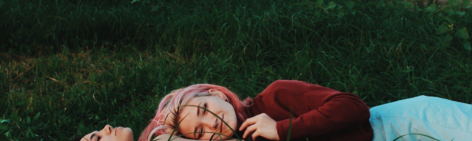 girlfriends lying in a grassy field