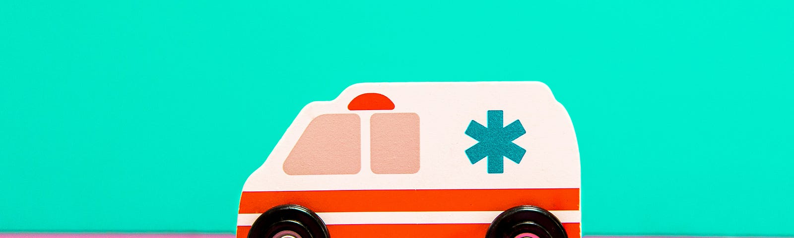 A cartoon illustration of an ambulance driving to the left on pink pavement. The sky is green.