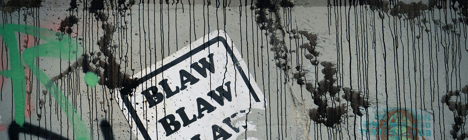 A sticker on a graffitti wall that says “blah, blah, blah”