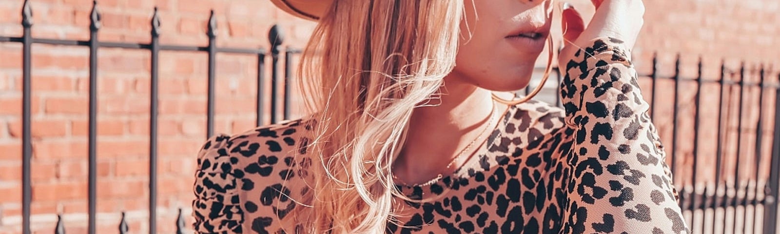 Young blond woman in a leopard print top looking off to the side