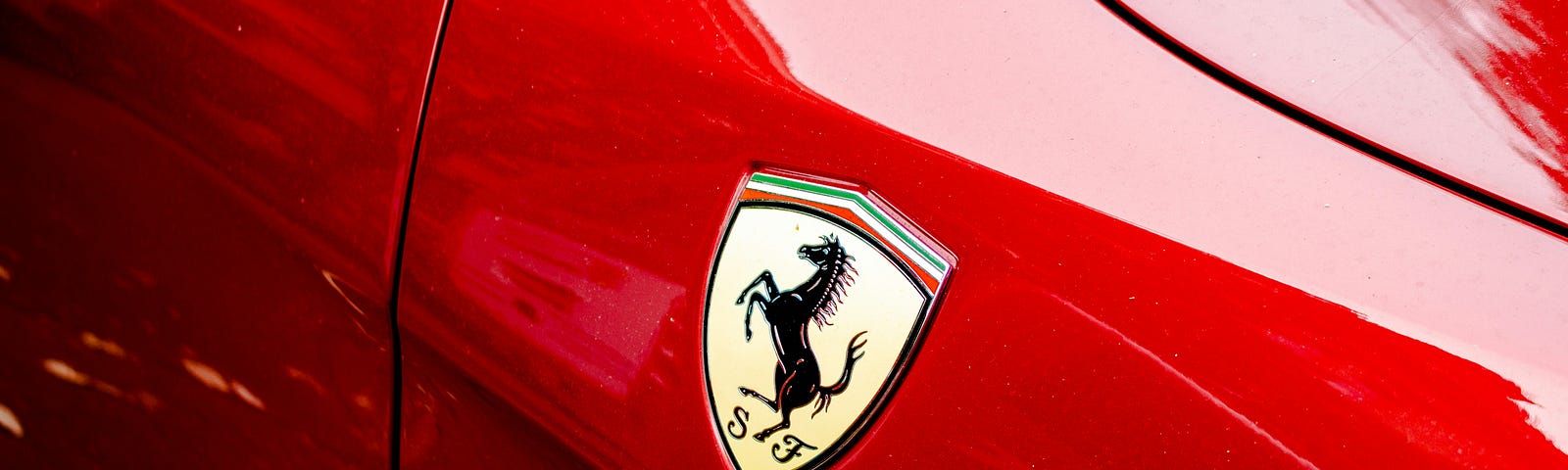 Ferrari Prancing Horse symbol on the side of a red car.