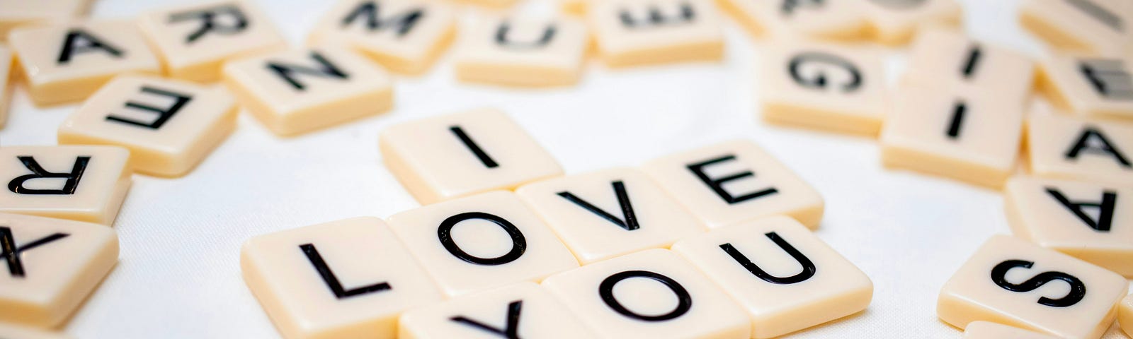 Scrabble tiles that spell out “I love you,” surrounded by a board full of random letters.