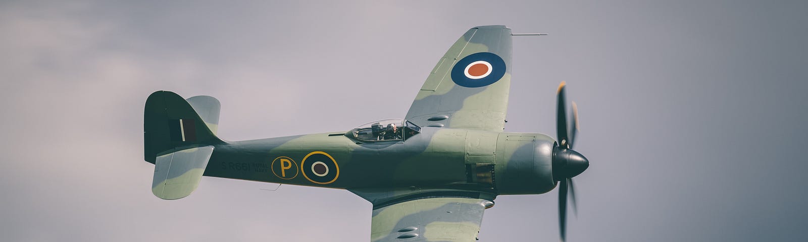 A Spitfire in the air with clouds in thh background