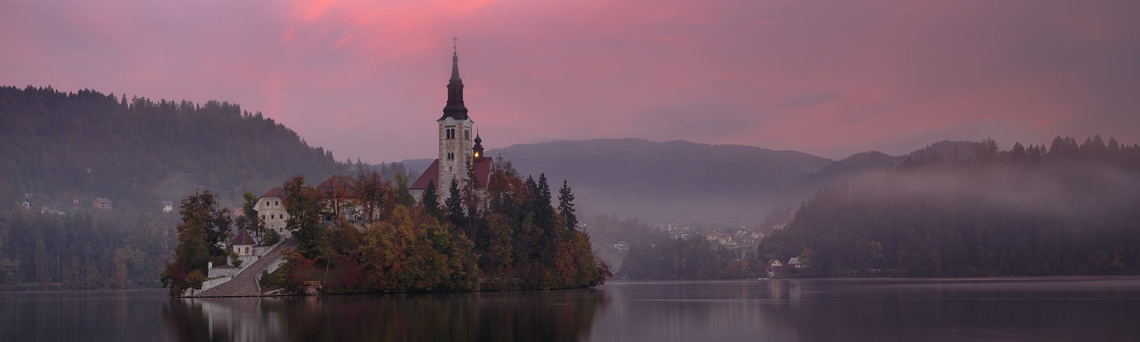 sunrise over hills and a castle on an island