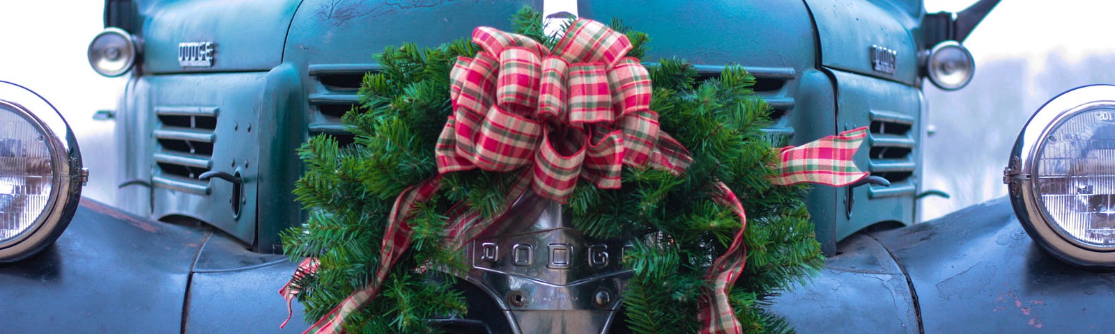 Antique blue pick up truck with Christmas wreath on front