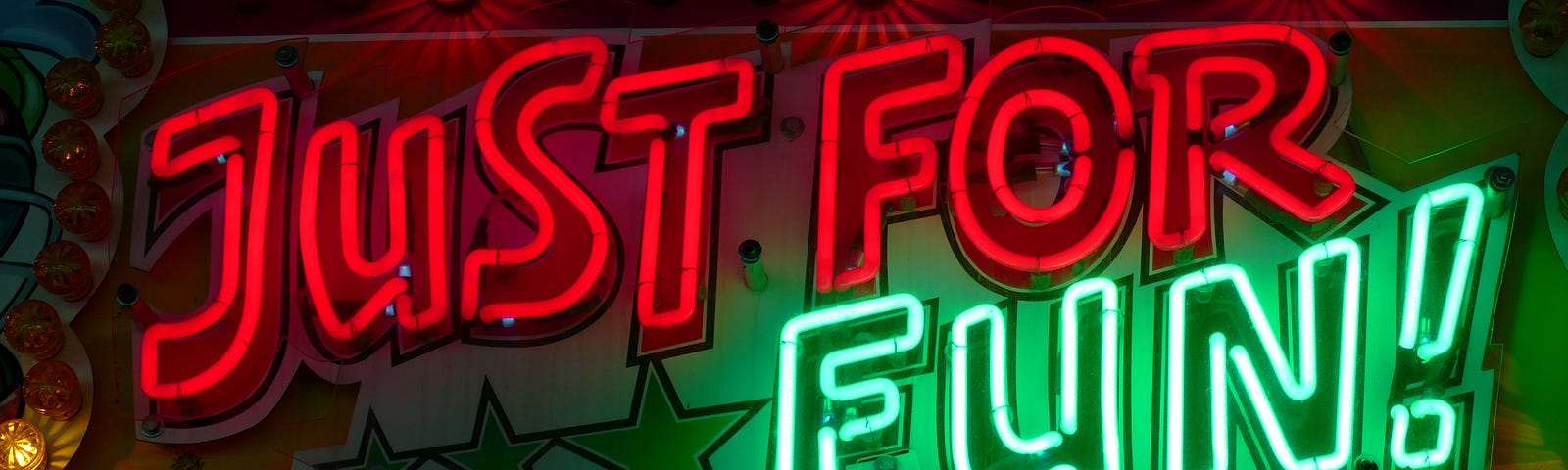 image shows a neon sign that reads “Just For Fun” in red and green lights