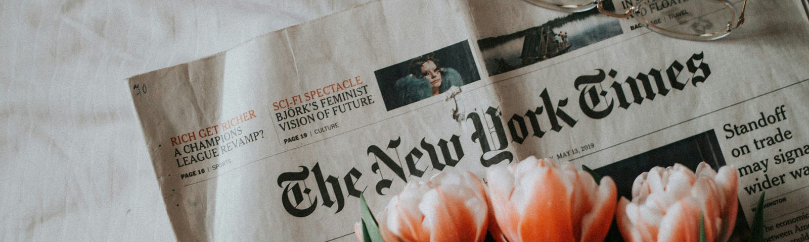 The New York Times, with a boquet of tulips and a pair of glasses on it. An ode to and an apology for my underinformed interpretation of a Times article.