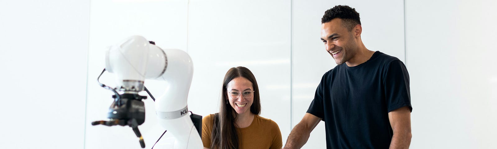 man and woman watching robot work