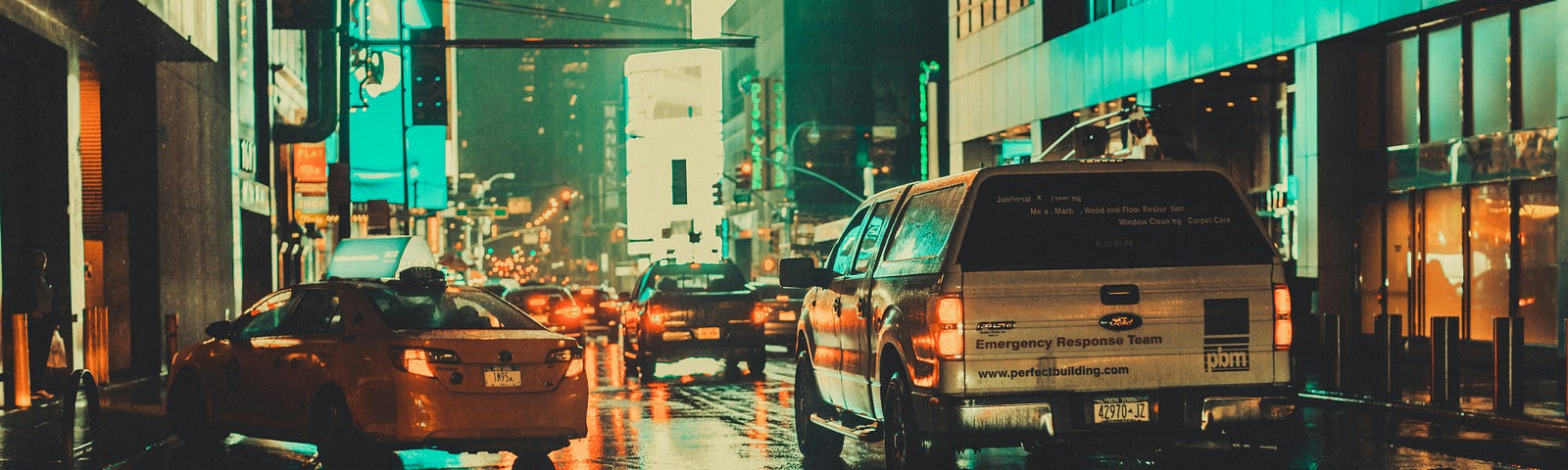 Cars driving on the street in the night.