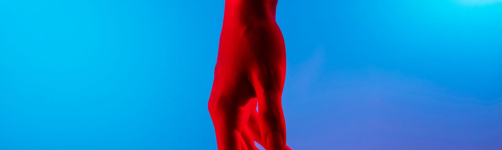 A red hand hanging limp in front of a blue screen