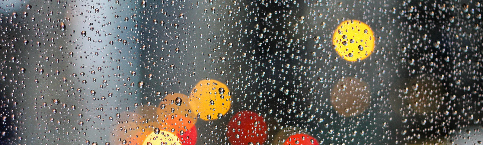 Spotty colored lights through a rainy window