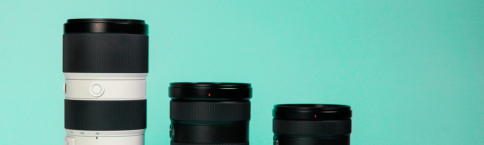 Four camera lenses lined up from left to right on a blue background