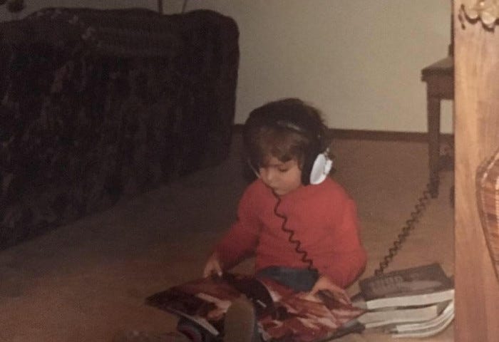 Young child listening to music through headphones in the late 1970s.