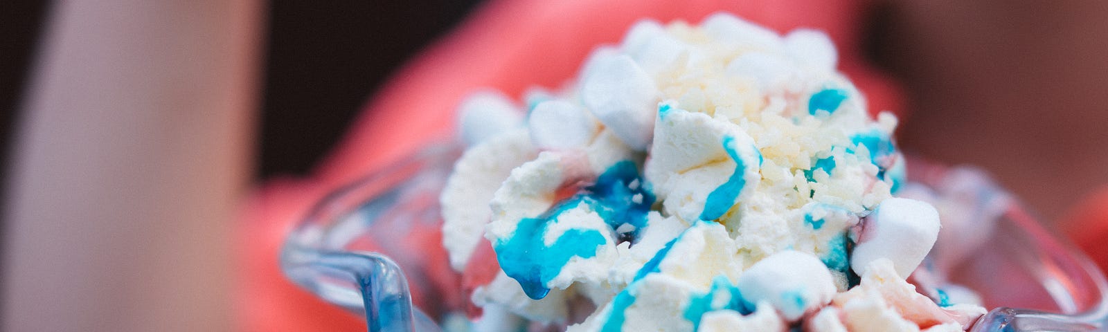 child eating ice cream with blue and chocolate sauce swirled