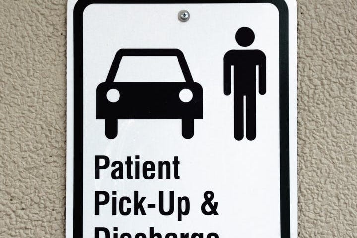 Road sign: “Patient Pick-Up & Discharge Only,” with image of car and human above the words