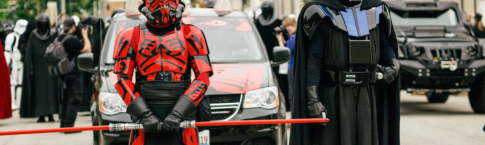 Two Star Wars cosplayers, one dressed as Darth Maul, the other dressed as Darth Vader.