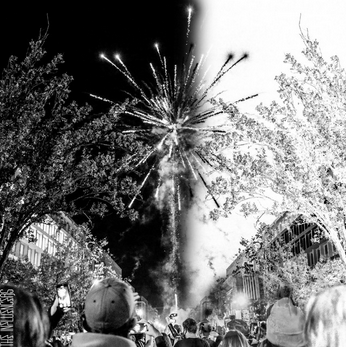 The Influencers “Champagne” single cover art; firework in city street framed by two trees on either side with grayscale filter, left half black tones and right half white tones
