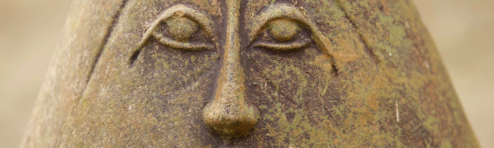 An anciet status has a very open, vertical oval-shaped mouth.