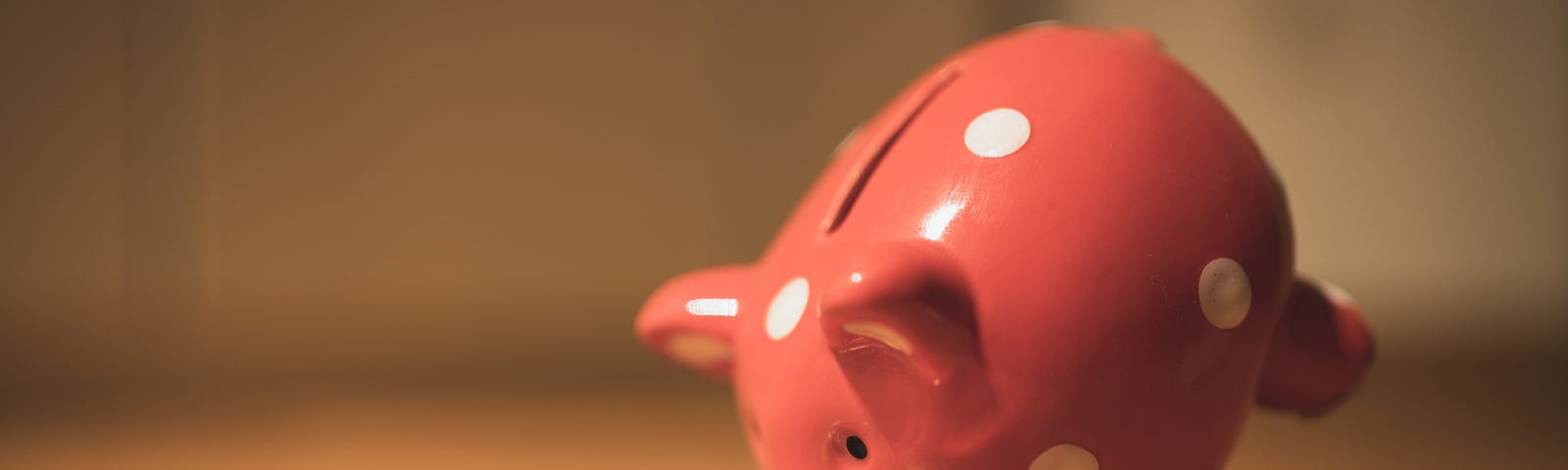 The Sunk Cost Fallacy — A Fallen Piggy Bank and Coins on a Table