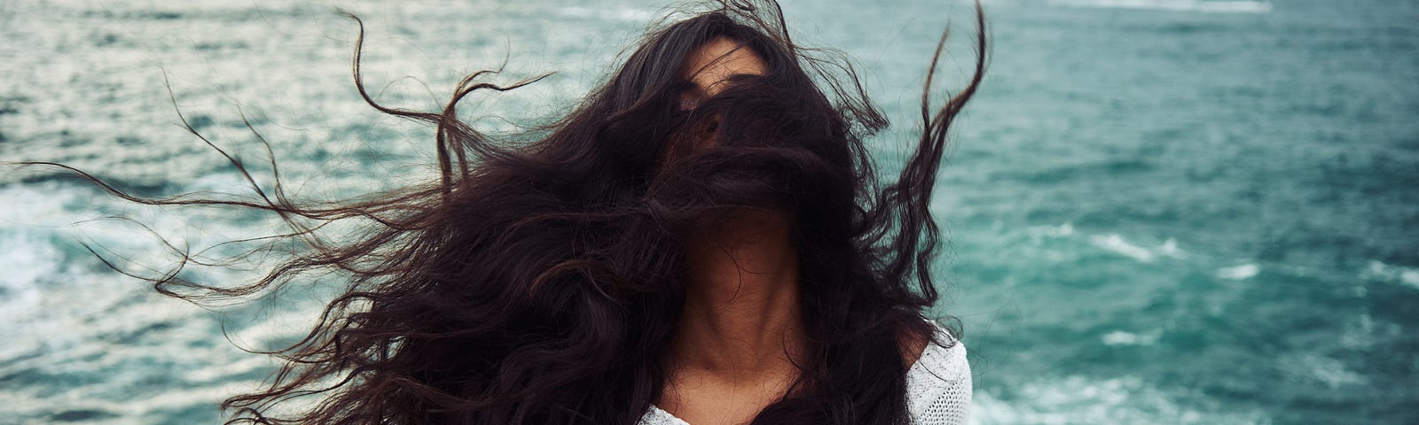 A woman wait long, brunette, wind-blown hair