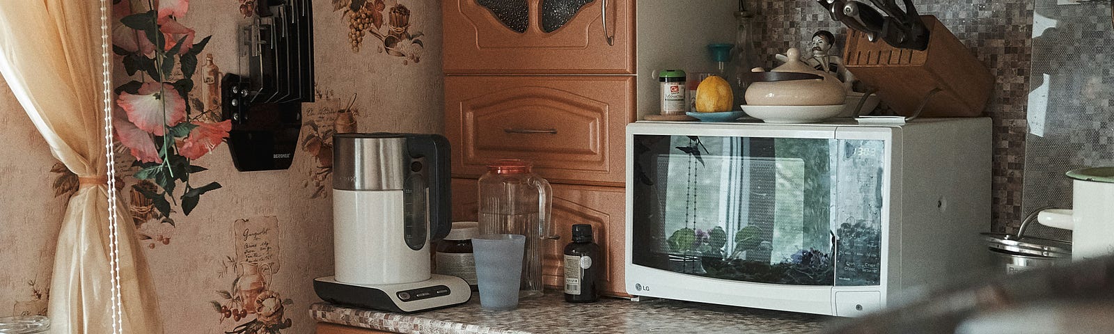 a cluttered kitchen with a microwave