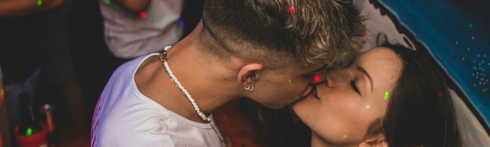 This shows a young couple kissing in a club.