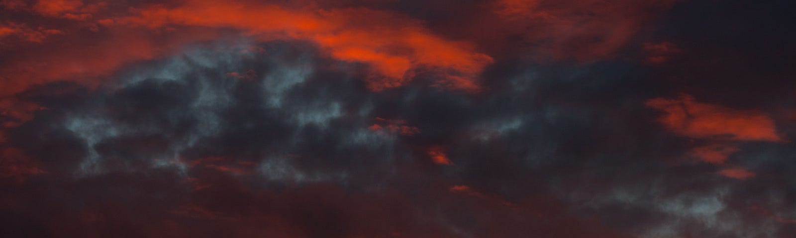 A fierce sky with dark red and grey clouds