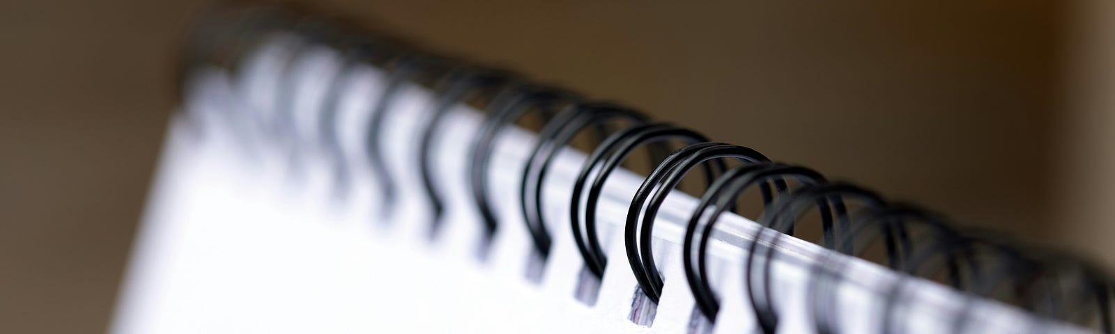A corner of a white notebook with black spiral-binding. This shown as a play on words with data ‘binding’