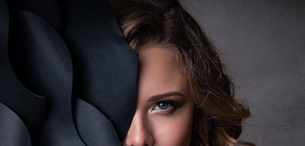 Image of a women whose half face is covered with a black object