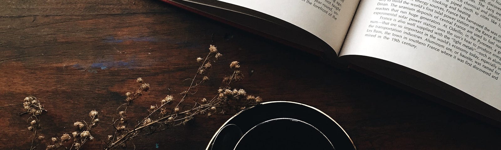 Hand with coffee cup, and open book