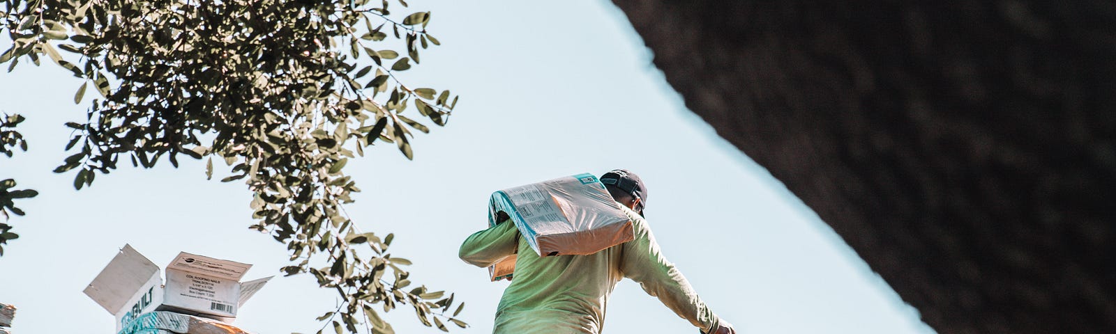 A man carries a bundle on a roof