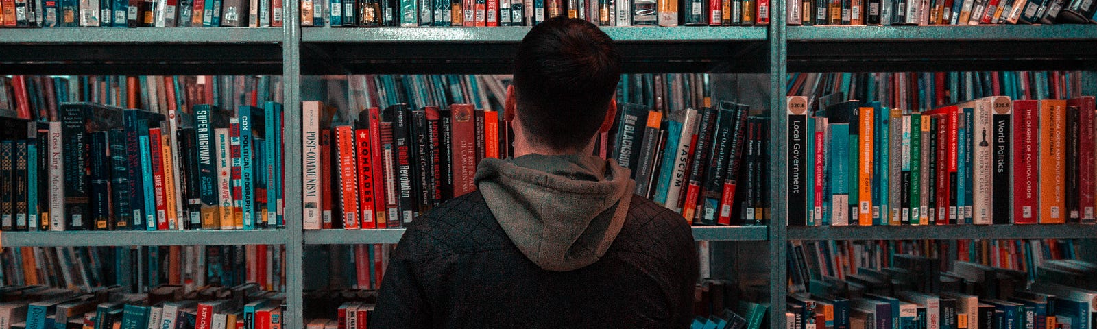 A man looks at a bookcase in a library