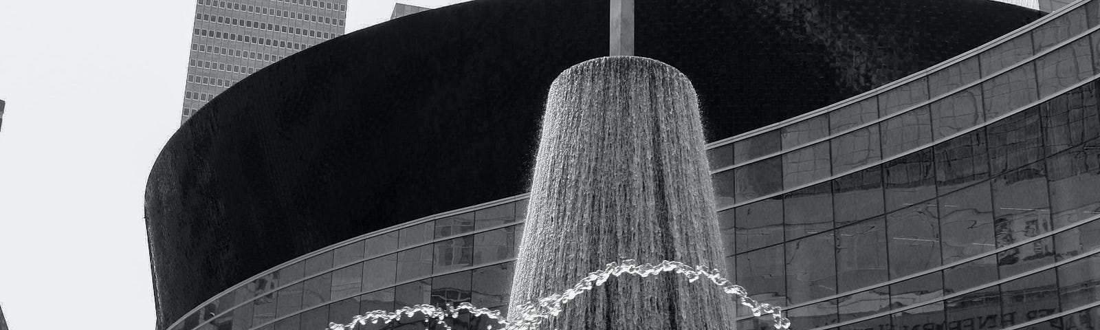 A black and white photo of the headquarters of the Southern Baptist Convention. A several story rounded building with a fountain in front.