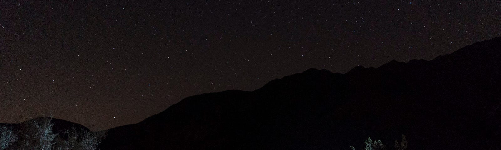 A tent outside on a stary night