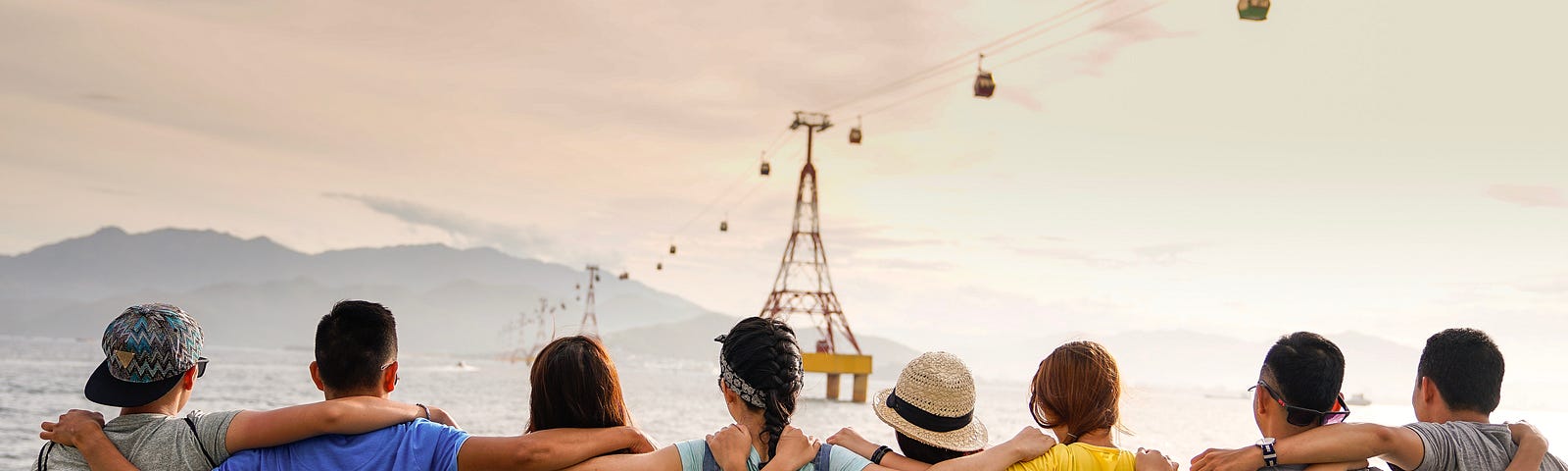 A group of differently-sized and aged people with their arms around each others backs. Got each others back with a cooperative chain.