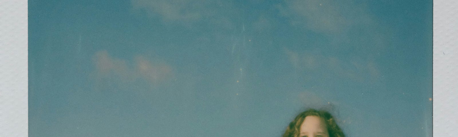 Photograph of two children outside under the blue sky.