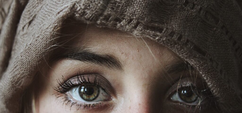Eyes of a Person Looking Through a Brown Piece of Clothing Covering The Face