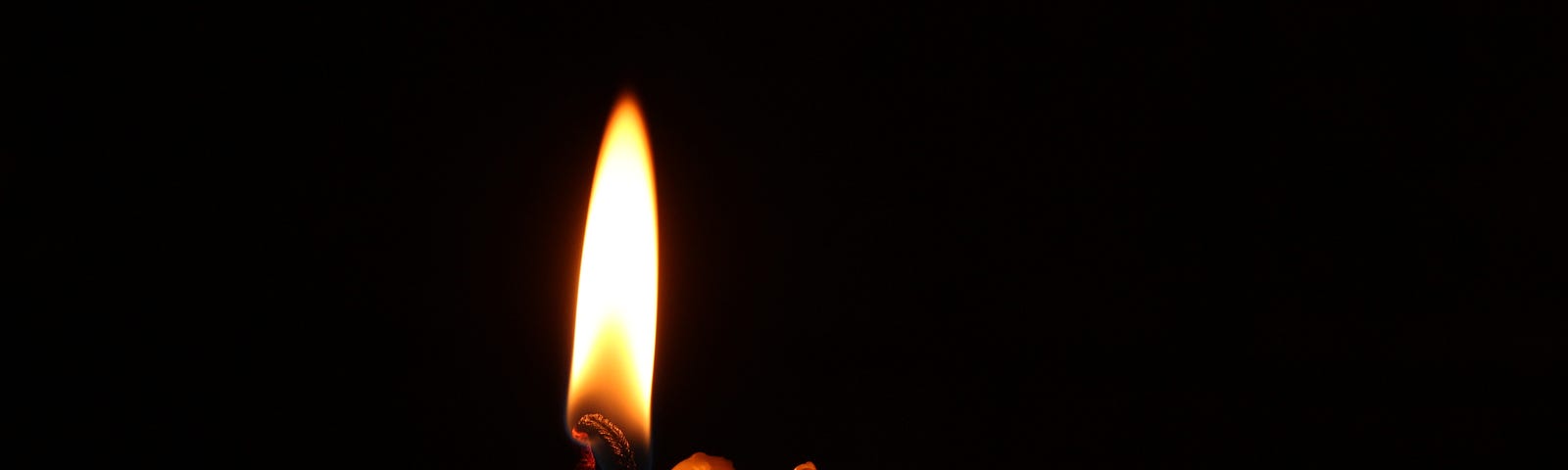 A lit candle with various purposes