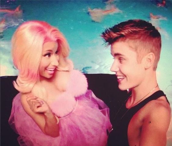 Nicki and Justin smiling at each other, screenshot from the “Beauty and a Beat” music video.