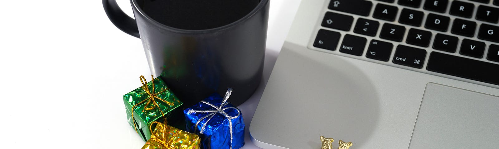 A laptop, a cup, and some tiny presents with the words ‘Merry Christmas’