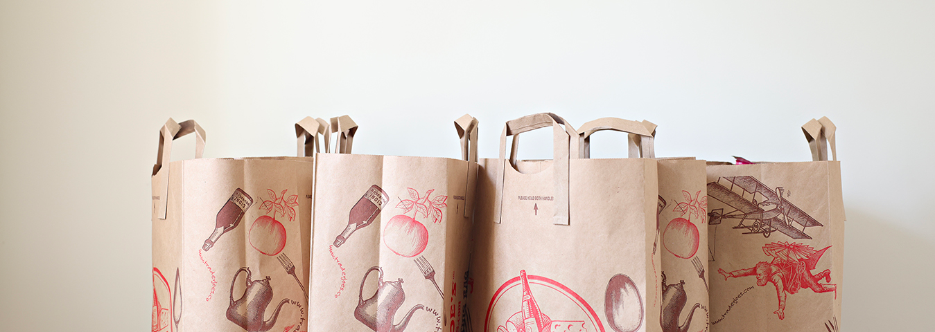 Four paper grocery bags with Trader Joe’s logos on them.