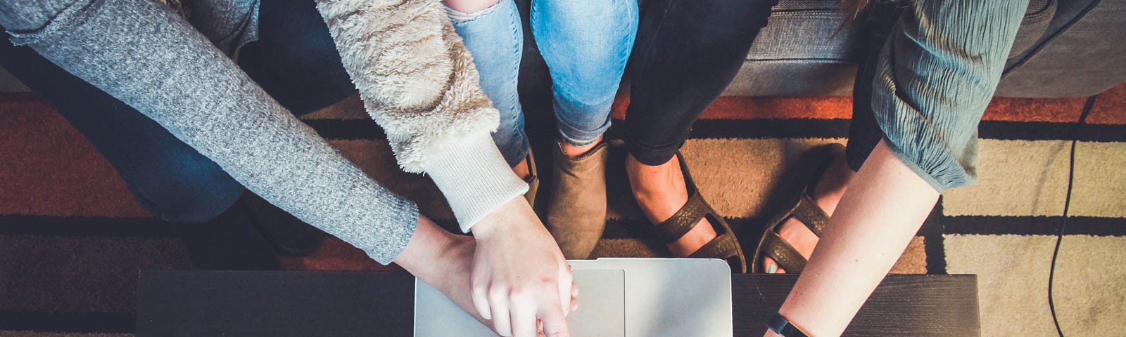 3 people touching a laptop